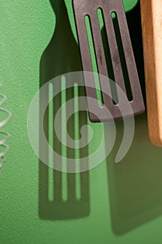 Different kitchen tools for cooking hanging on the wall.