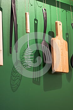 Different kitchen tools for cooking hanging on the wall.