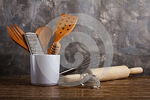 Different kitchen utensilson concrete wall background