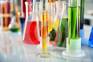 Different laboratory glassware with colorful liquids on table, closeup