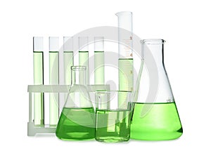 Different laboratory glassware with light green liquid isolated on white