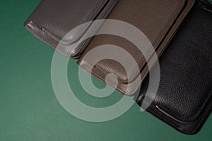 Different leather wallets on zipper. Green background.