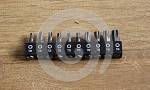 Different lengths of drilling machine bits on wooden background