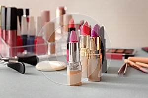 Lipsticks and different cosmetics on table