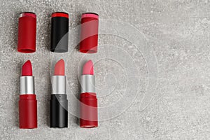 Different lipsticks on grey table, flat lay. Space for text
