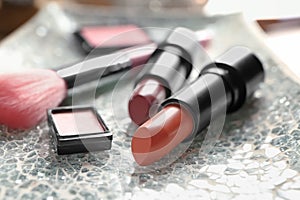 Different lipsticks and other cosmetics on table