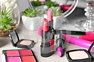 Different lipsticks and other cosmetics on table