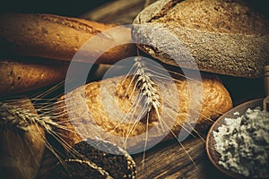 Different loaves of bread cooked with flour and gluten-free wheat on a wooden table