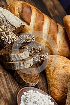 Different loaves of bread cooked with flour and gluten-free wheat on a wooden table