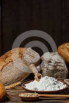 Different loaves of bread cooked with flour and gluten-free wheat on a wooden table