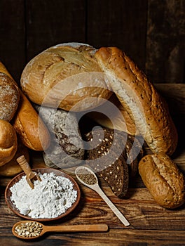 Different loaves of bread cooked with flour and gluten-free wheat on a wooden table