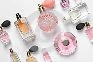 Different luxury perfume bottles on white background