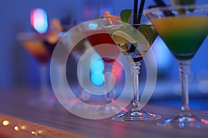 Different martini cocktails on table against blurred background