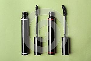 Different mascaras for eyelashes on light background, flat lay. Makeup product