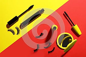 Different mascaras, fake eyelashes and mirror on color background, flat lay. Makeup product
