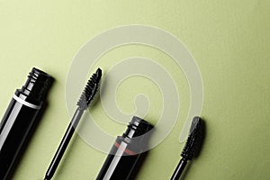 Different mascaras on light background, flat lay with space for text. Makeup product