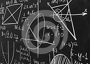 Different mathematical formulas written with chalk on blackboard