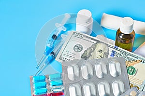 Different medicaments and money on blue background. Medical concept. Doctor salary. Corruption in healthcare