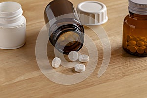 Different medicine bottles and round white pills