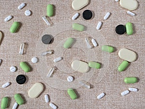 Different medicines are scattered and evenly distributed on a beige textured background.
