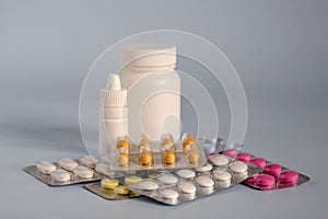 Different medicines- tablets and pills in blister pack, medications drugs and white plastic medical containers. Close-up.