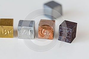 Different metal cubes on cream background