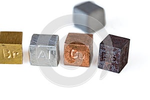 Different metal cubes on white background