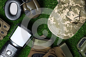 Different military training equipment on green grass, flat lay