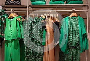 different models green and dresses blouses in the store grouped in the color