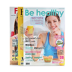 Different modern printed magazines on white