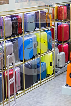 Different modern travel suitcases in the shop on discount, seasonal sale at the department store