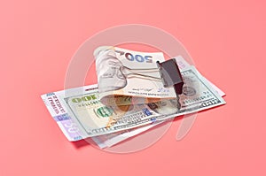 Different money with metal clip on pink background. Payment of pensions, salaries