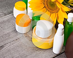 Different natural body care cosmetic products and sunflowers