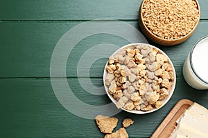 Different natural soy products on green wooden table, flat lay. Space for text