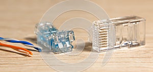 Different Network Connectors rj-45 with a cable on wood table. Close-up, selective focus