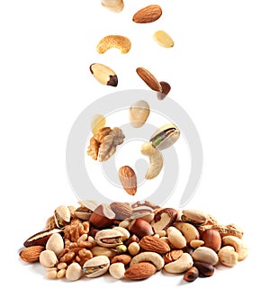 Different nuts falling into pile on background