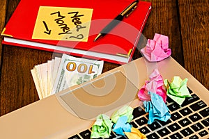 Different objects on wooden office desk. Modern wooden office desk table with laptop keyboard, office agenda, money and a colorful