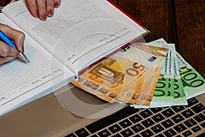 Different objects on wooden office desk. Modern wooden office desk table with laptop keyboard, euro money, office agenda. Business