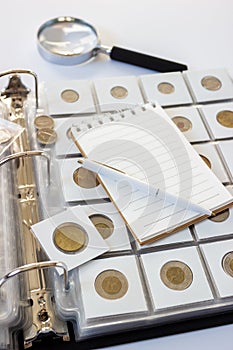 Different old collector`s coins with a magnifying glass