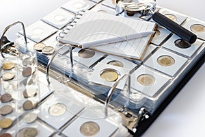 Different old collector`s coins with a magnifying glass