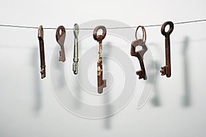A different old retro rusty keys from different locks hanging on string
