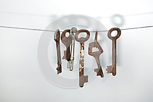 A different old retro rusty keys from different locks hanging on string