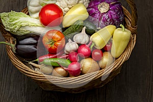 Different Organic Fruits and vegetables in basket on wooden table back