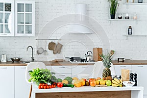 Different organic fruits and vegetables on moderm white colored kitchen. Healthy nutrition.