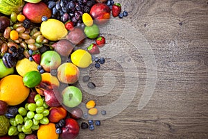 Different Organic Fruits with water drops on wooden table back