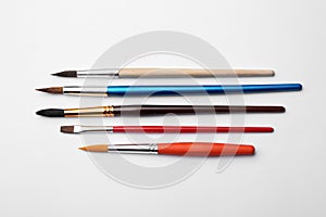 Different paint brushes on white background