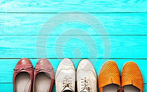 Different pairs of female shoes on blue wooden floor, Top view and copy space. Mock up.