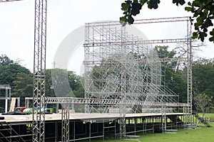Different parts of metal scaffold on the construction field. Workers build a concert stage. Stage equipment