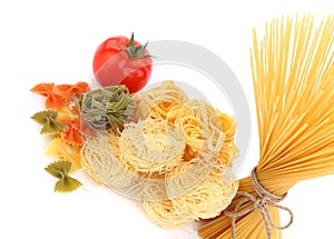 Different pasta and tomato on a white background