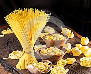 Different pasta types on wooden table.
